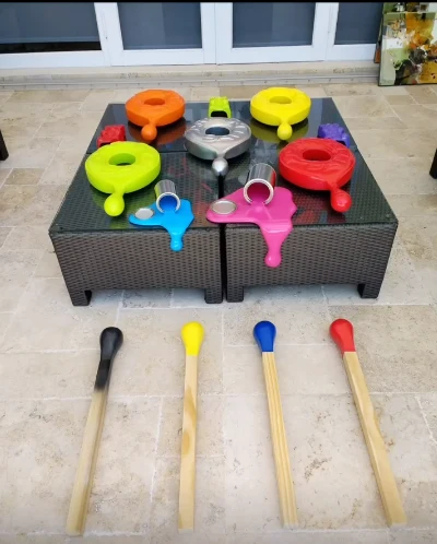 Instalación con piezas de colores que gotean sobre una mesa y cuatro fósforos gigantes en el piso